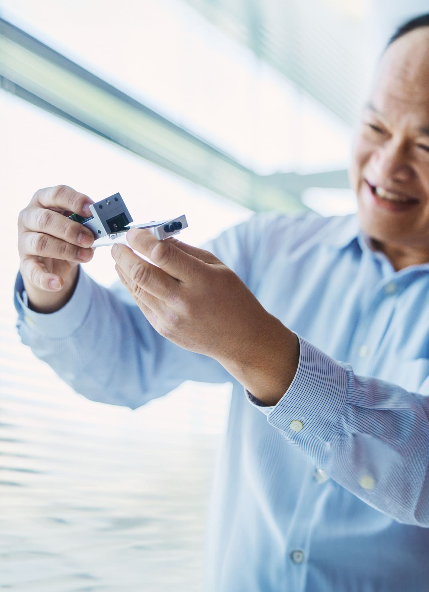 技術研究所にて下肢スポーツベット サッカー 夏期をもつ社員の劉銘祟さんが模型を使って説明している様子