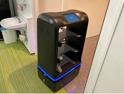 セキュリティ自動ドアなどのスポーツベット 掲示板設備と連動し、配送を行うロボットの様子